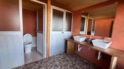 a bathroom with two sinks and a toilet at Titicaca Lodge Amantani in Amantani