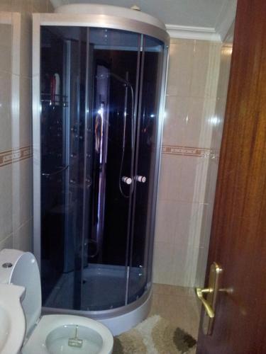 a bathroom with a glass shower with a toilet at Casa do castelo in Penamacor