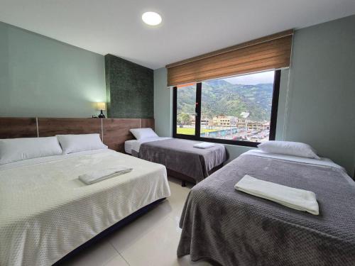Una habitación de hotel con dos camas y una gran ventana. en Apartment 7 with Jacuzzi in the center - 3 Bedroom 2 Bath, en Baños