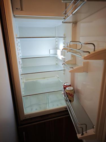 a refrigerator with its door open with a can of soda at Bijou Lungern in Lungern