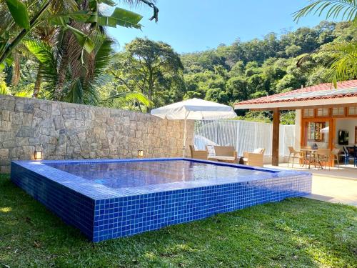 a swimming pool in the yard of a house at Casa Varanda Guaecá Pet Friendly, Heated Pool in São Sebastião