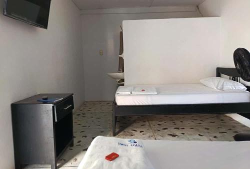 a small room with a bed and a tv in it at Hotel Efata in Apartadó