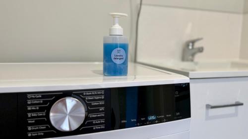 a bottle of detergent sitting on top of a microwave at Central Spot Elegant Home Fresh Features in Auckland