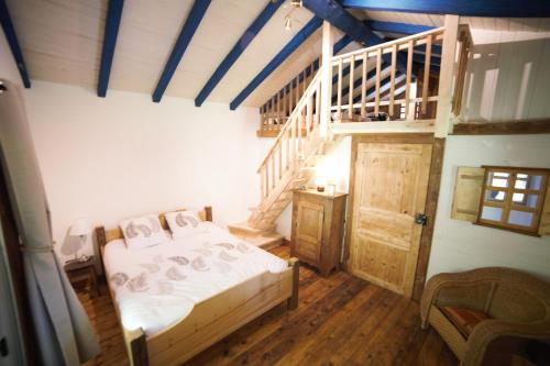 a bedroom with a bed and a wooden staircase at Gite des deux fontaines in Samoëns