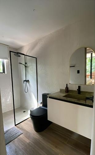 a bathroom with a sink and a toilet and a mirror at Avani in Contadora
