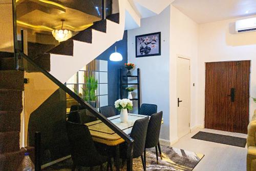 a dining room with a table and some chairs at D'Vista Apartments in Ikota