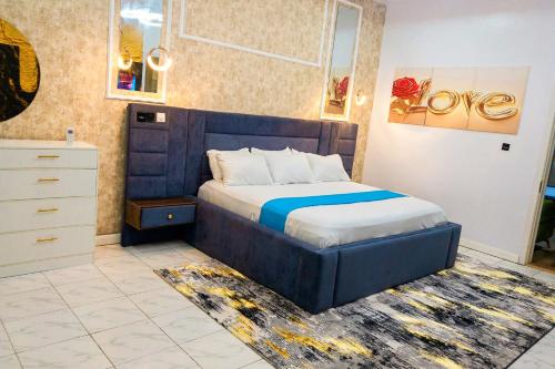 a bedroom with a bed and a dresser at D'Vista Apartments in Ikota