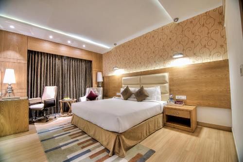 Habitación de hotel con cama y escritorio en Best Western Summerlea jalandhar, en Jalandhar