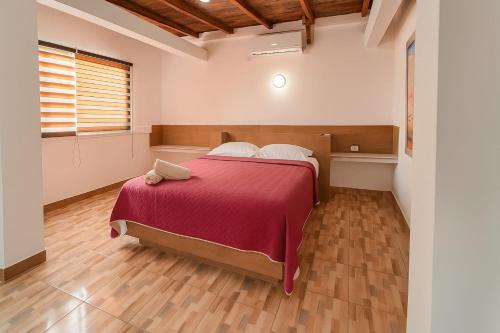 une chambre avec un grand lit avec une couverture rouge dans l'établissement Terramar Hoteles, à Crucita