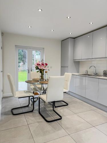 a kitchen with a table and chairs and a vase of flowers at Middleton Mews- 3BR- Wollaton Park-Hospital & Uni in Nottingham