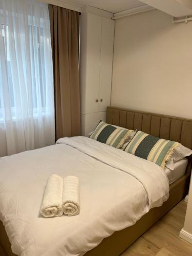 a bedroom with two towels on a bed with a window at Apartament Iulius Mall Cluj in Cluj-Napoca