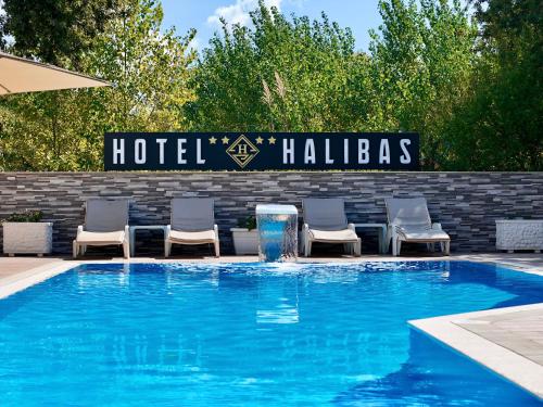a swimming pool with chairs and a hotel hollywood sign at Hotel Halibas in Ulcinj