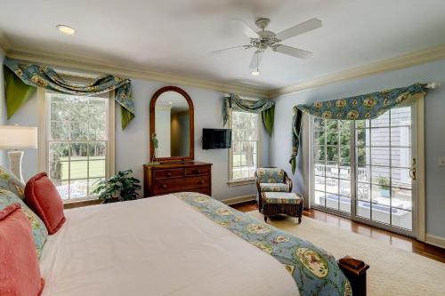 a bedroom with a bed and a fan and windows at GE317: 317 Glen Eagle in Kiawah Island