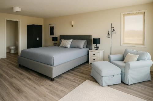 a bedroom with a bed and a couch and a chair at Hot-tub, Games Room, Walk-in Sauna, 7 BM, 15 mins to Waterton in Mountain View