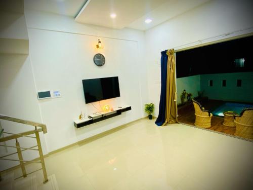 a living room with a flat screen tv on the wall at prahi villa 3bhk in Lonavala