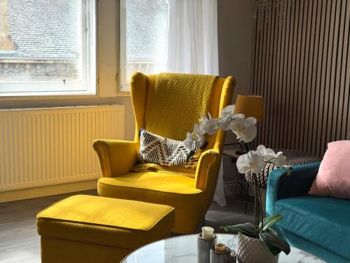 a living room with a yellow chair and a table at Falkirk City Centre Stylish Two-Bedrooms Apartment in Falkirk