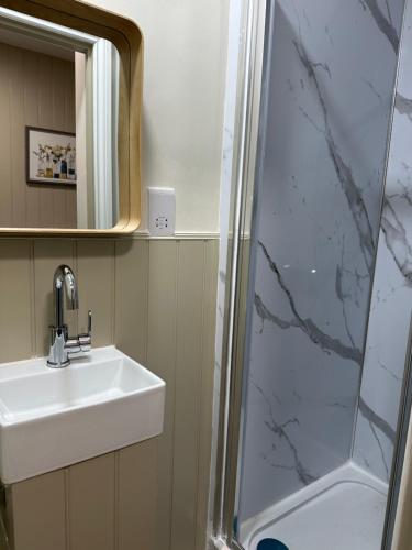 a bathroom with a sink and a shower at LORD MERIT GUEST HOUSE KING'S CROSS GRAYS INN ROAD in London