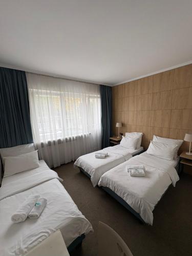 a hotel room with two beds with towels on them at Villa Gold Poznań in Poznań
