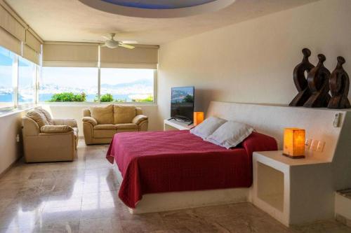 a bedroom with a red bed and a living room at Villa MAJUM Acapulco in Acapulco