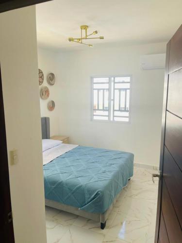 Un dormitorio con una cama con una manta azul. en perfect villa, en Punta Cana
