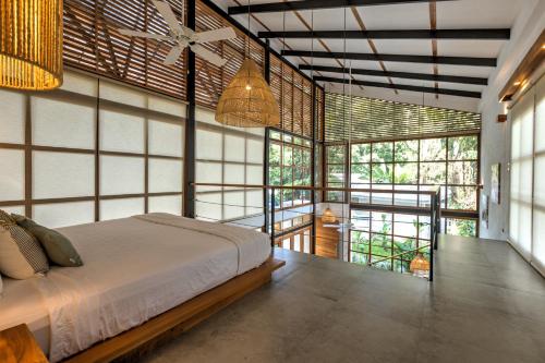 une chambre avec un lit dans une pièce avec des fenêtres dans l'établissement Porto Alegre Resort, à Punta Uva