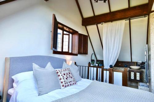 a bedroom with a white bed and a window at Characterful holiday home in Oxfordshire Cotswolds 