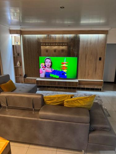 a living room with a couch and a flat screen tv at Pillowtalk guest house your home away from home in Middelburg