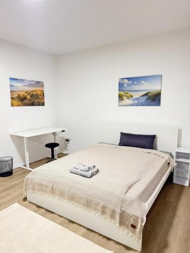 Un dormitorio blanco con una cama y un escritorio. en City-Apartment - zentral mit schöner Terrasse, en Herne