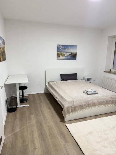 Un dormitorio blanco con una cama y un escritorio. en City-Apartment - zentral mit schöner Terrasse, en Herne
