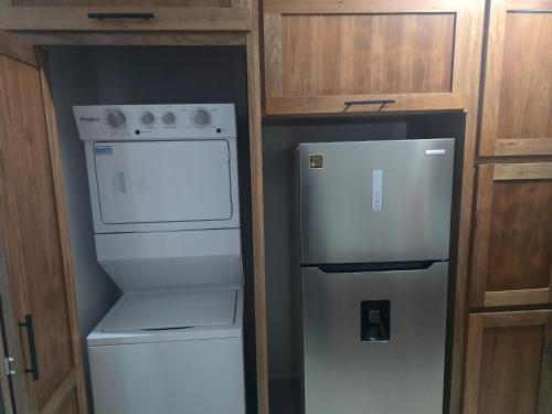 a kitchen with a refrigerator and a washer and dryer at Sunrise Apartments in San Felipe de Puerto Plata