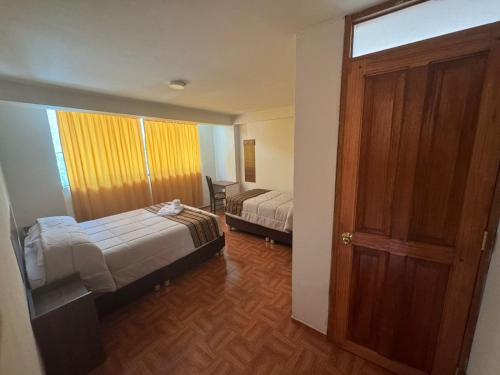 a room with two beds and an open door at Refugio Sagrado Boutique Ollantaytambo in Ollantaytambo