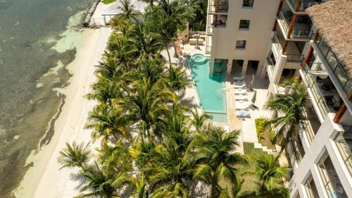 an aerial view of a resort with a pool and palm trees at 3BR Beachfront Elegant Condo -Family Getaway in Isla Mujeres