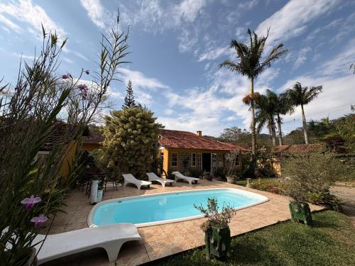 una piscina en el patio de una casa en Pousada Jardim Secreto, en Teresópolis