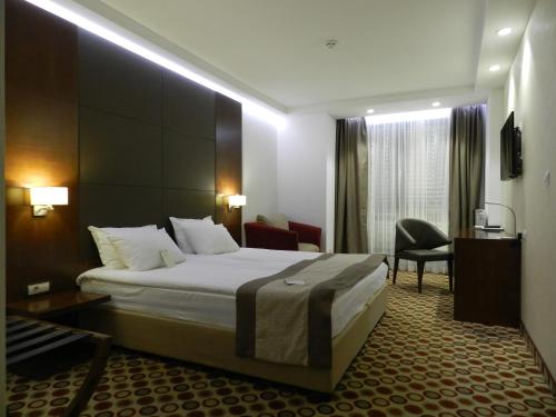 um quarto de hotel com uma cama e uma cadeira em Central Hotel Sofia em Sófia