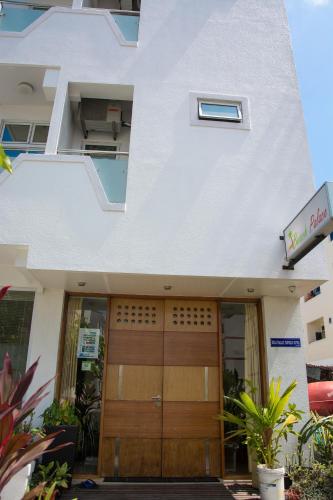 a white building with a wooden door in front of it at Beach Palace in Hulhumale