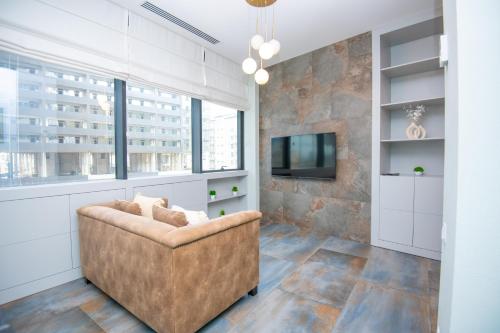 a living room with a couch and a tv at New Stylish 1 BR apartment in Axis Towers in Tbilisi City