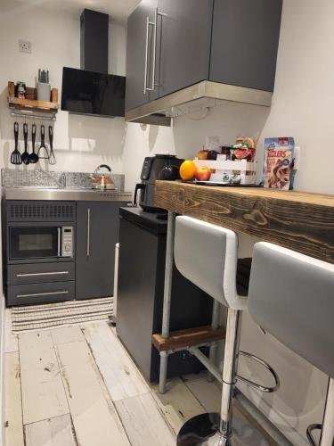a kitchen with black cabinets and a wooden counter top at Rūm by the beach in Camber