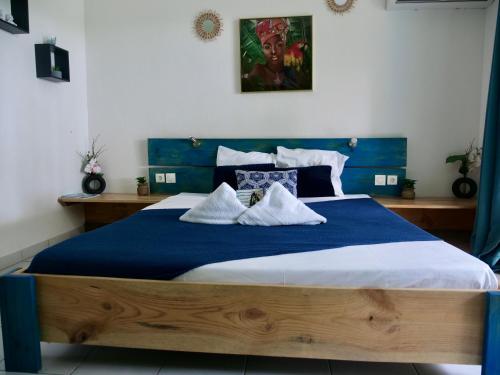 a bedroom with a blue and white bed with pillows at Studio au soleil, plage privée in Grand-Bourg