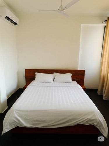 a white bed with two pillows in a bedroom at Zurihomes in Dar es Salaam