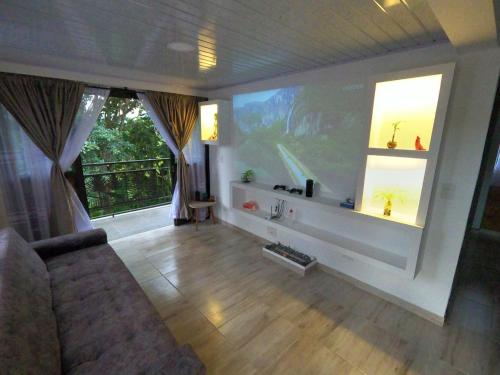 a living room with a large screen and a couch at Cabaña privada cerca de Armenia Quiet Mountain View Country Home in Salento