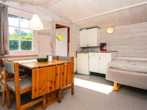 a kitchen and dining room with a table and a bed at Lush cabin in camping resort in Aabenraa