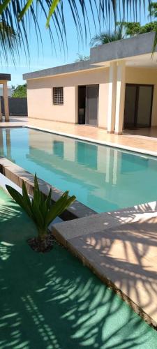 a swimming pool with a house in the background at Villa de luxe à Ngaparou Saly center in Mbour