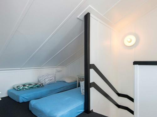 ein Zimmer mit zwei blauen Betten auf dem Dachboden in der Unterkunft 7 person holiday home in Ebeltoft in Ebeltoft