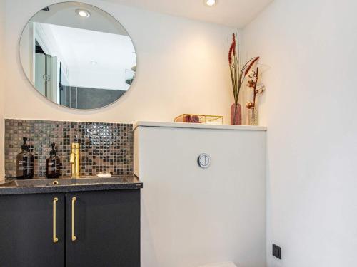 ein Badezimmer mit Waschbecken und Spiegel in der Unterkunft 7 person holiday home in Ebeltoft in Ebeltoft