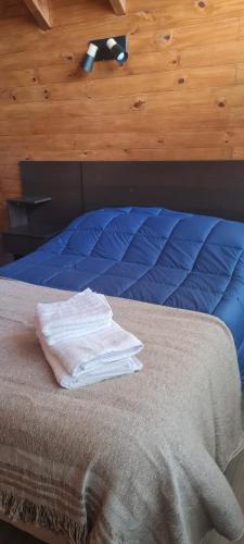 a bed with two towels sitting on top of it at Al pie del león in Ñirihuau