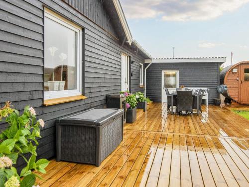une terrasse avec une table et des chaises sur une maison dans l'établissement Luxury Spa Retreat in Thorsminde - By Traum Ferienwohnungen, à Ulfborg