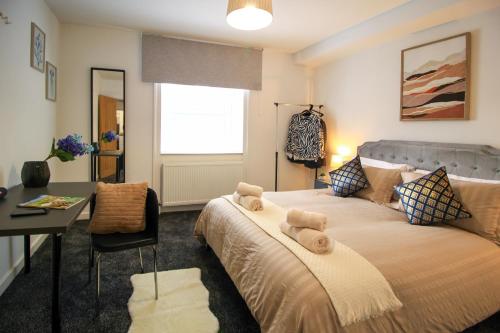 a bedroom with a bed with a desk and a window at Spacious 1 Bedroom City Center Flat in Derby in Derby