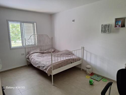 a small bedroom with a bed and a window at נוף לגלבוע in Bet Sheʼan