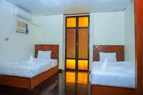 a bedroom with two beds and a door to a room at King palace castle hotel in Cairo