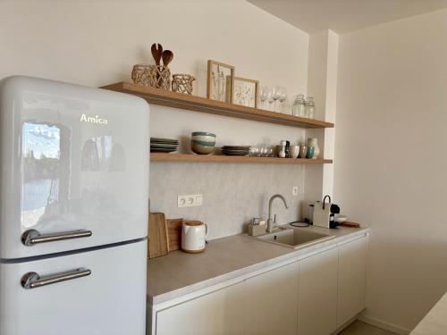 a kitchen with a white refrigerator and a sink at Bluewave boho apartment Slnava in Banka